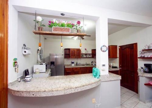 a kitchen with a counter and a refrigerator at Casa con alberca y amplio espacio para tu familia in Playa del Carmen