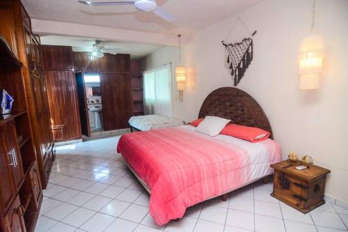 a bedroom with a large bed with a red blanket at Casa con alberca y amplio espacio para tu familia in Playa del Carmen