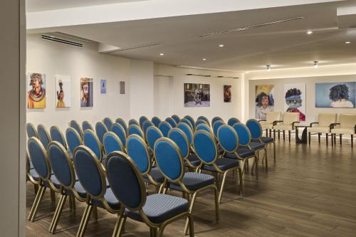 a row of chairs in a room with paintings at The Ven at Embassy Row, Washington, D.C., a Tribute Portfolio Hotel in Washington