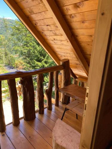 a wooden porch with a bench and some trees at Cottage Under the Tresnjevik in Andrijevica