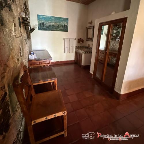 a room with a chair and a table and a door at Posada de la Mision, Hotel Museo y Jardin in Taxco de Alarcón