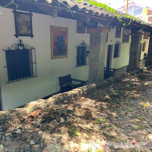 a house with a porch with a bench on it at Posada de la Mision, Hotel Museo y Jardin in Taxco de Alarcón