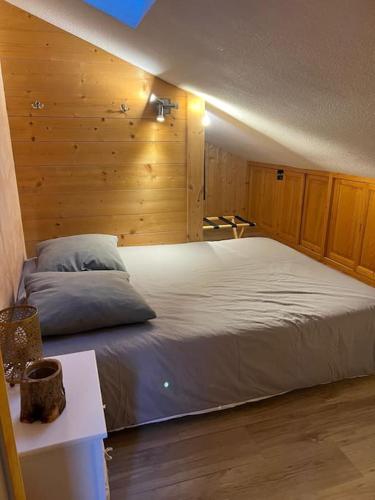 - une chambre avec un grand lit et des murs en bois dans l'établissement Appartement cosy proche Châtel Portes du soleil - linge inclus, à Abondance