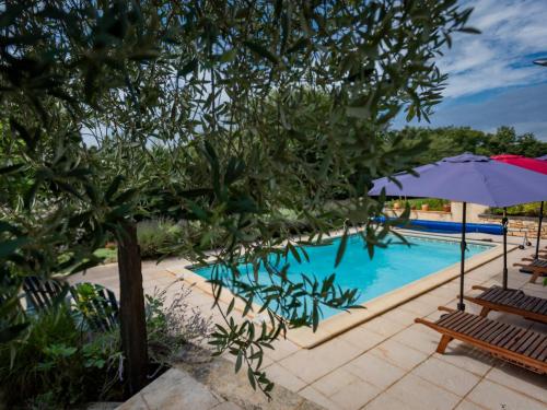 une piscine avec des chaises et un parasol dans l'établissement Maison Micouleaud, à Besse