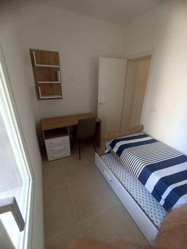 a small bedroom with a bed and a desk at Appartamento dei Cedri in Marotta