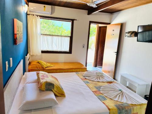 Ένα ή περισσότερα κρεβάτια σε δωμάτιο στο Pousada Canto dos Golfinhos