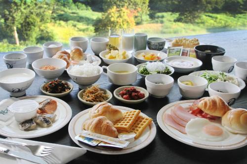 a table with plates of food and bowls of food at Rockwood Hotel & Spa in Ajigasawa