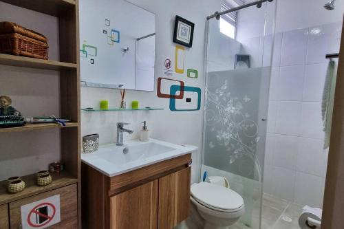 Un baño con inodoro, lavabo y ducha. en Acogedora y amplia casa en Anapoima con piscina en condominio cerrado - hasta 8 personas, en Anapoima