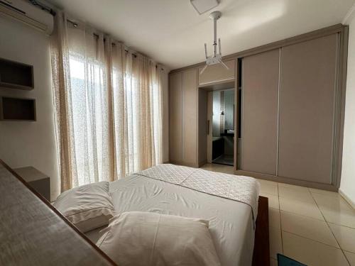 a bedroom with a bed and a large window at Casa Aconchegante no Centro de Cianorte in Cianorte