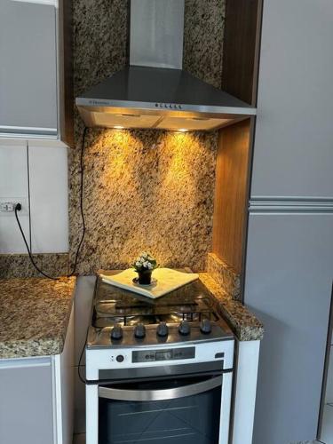 a kitchen with a stove top oven in a kitchen at Casa Aconchegante no Centro de Cianorte in Cianorte
