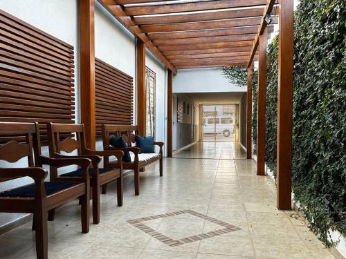a patio with chairs and awning and a hallway at Casa Aconchegante no Centro de Cianorte in Cianorte