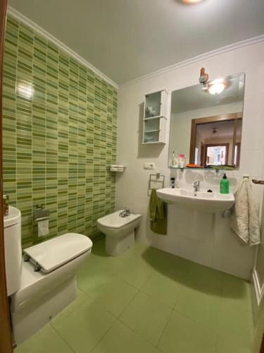a bathroom with a toilet and a sink and a toilet istg at Apto Cedeira a 3 mins playa in Cedeira