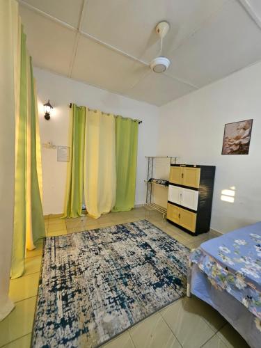 a room with green and yellow curtains and a rug at Homestay Sarah Ali Kuantan 3BEDROOM 2WASHROOM SELESA,BERSIH & LUAS in Kuantan
