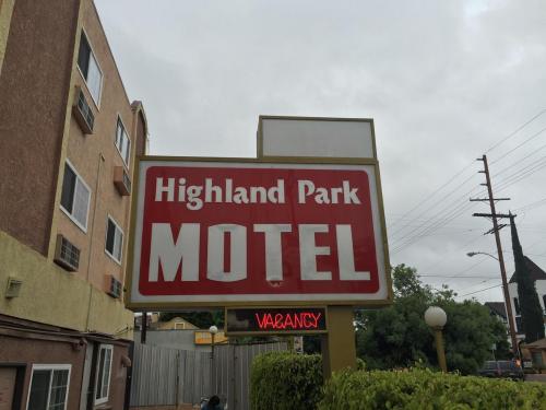 
a sign on a pole in front of a building at Highland Park Motel in Los Angeles
