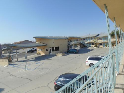 a parking lot with cars parked in front of a building at Western Inn & Suites in Taft