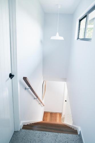 a staircase in a house with white walls at The Mysa Motel in Gold Coast