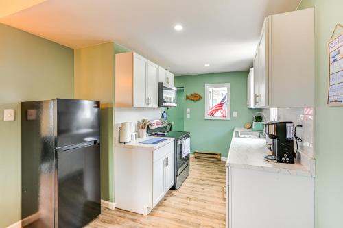 a kitchen with white appliances and green walls at Serene Lakefront Standish Home with Fire Pit and Grill in Standish