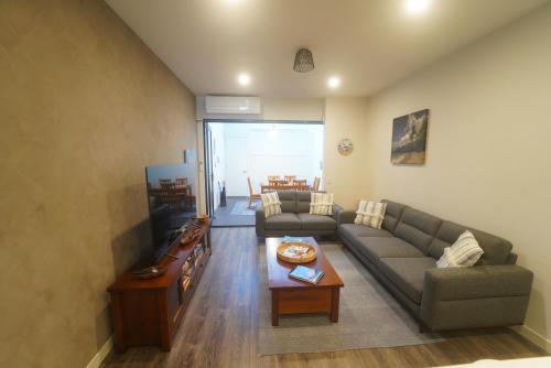 a living room with a couch and a table at Modern air-conditioned 3-bedroom townhouse in centre of Cape Woolamai in Cape Woolamai