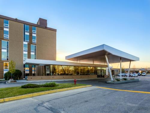 a building with a fire hydrant in a parking lot at Heritage Inn Hotel & Convention Centre - Saskatoon in Saskatoon