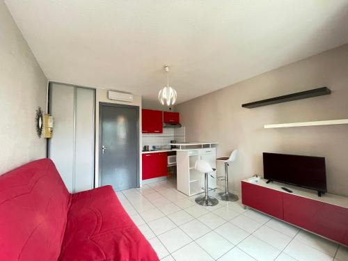 un salon avec un canapé rouge et une cuisine dans l'établissement Studio cabine cosy à Sète, proche plage - FR-1-338-337, à Sète