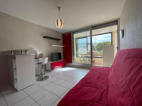 un salon avec un canapé rouge et une table dans l'établissement Studio cabine cosy à Sète, proche plage - FR-1-338-337, à Sète