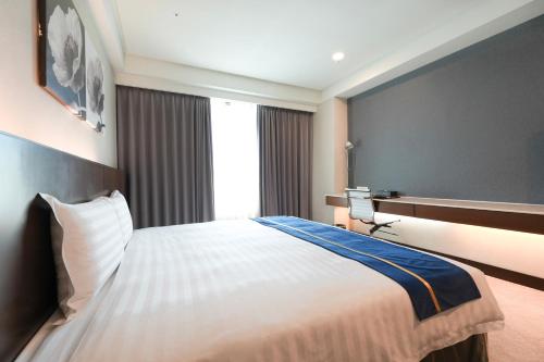 a hotel room with a bed and a window at Hi-YES Hotel Hualien in Hualien City