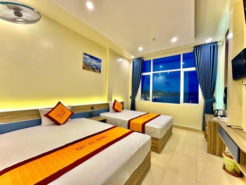 a hotel room with two beds and a window at THU HA SEA VIEW Hotel in Cat Ba