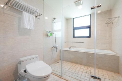a bathroom with a toilet and a shower and a tub at Hi-YES Hotel Hualien in Hualien City