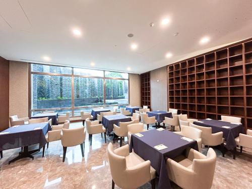 a dining room with tables and chairs in a library at Hi-YES Hotel Hualien in Hualien City