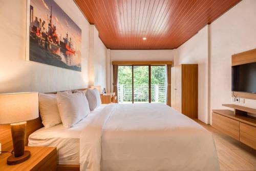 Un dormitorio con una cama grande y un televisor. en Made Canggu 77 Managed by Manara, en Canggu