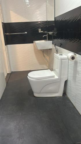 a bathroom with a white toilet and a sink at Himo Guest Inn in Dehiwala