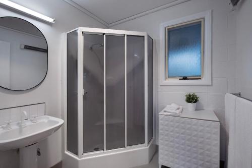 a white bathroom with a shower and a sink at The Cottage at Lake Werona in Werona