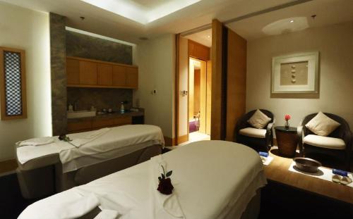 a hotel room with two beds and a chair at Shanghai Marriott Marquis City Centre in Shanghai