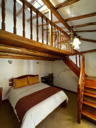 a bedroom with a large bed and wooden stairs at Huascaran Casa Boutique San Blas in Cusco