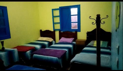 a room with four beds and a window at Casa bni maala in Beni Maala