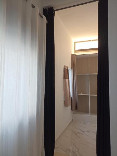 a bathroom with a window and a shower curtain at appartement vue sur mer plage des nations in Sale
