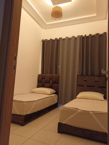 two beds sitting in a room with curtains at appartement vue sur mer plage des nations in Sale