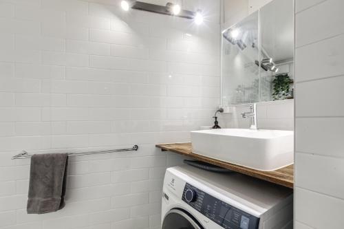 a laundry room with a sink and a washing machine at City Style - Steps to Emporium & Melbourne Central in Melbourne