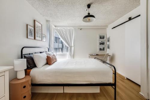 a white bedroom with a bed and a window at City Style - Steps to Emporium & Melbourne Central in Melbourne