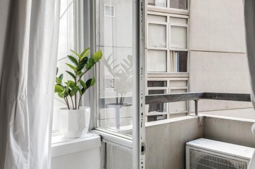 a window with a potted plant on a window sill at City Style - Steps to Emporium & Melbourne Central in Melbourne