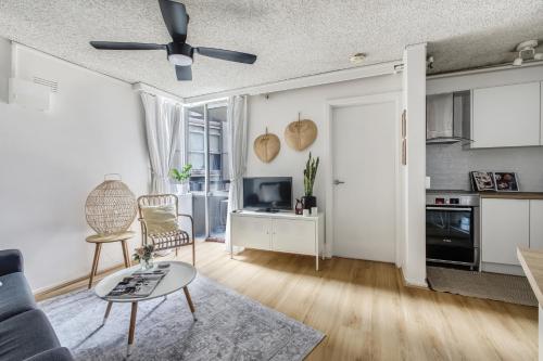 a living room with a couch and a ceiling fan at City Style - Steps to Emporium & Melbourne Central in Melbourne