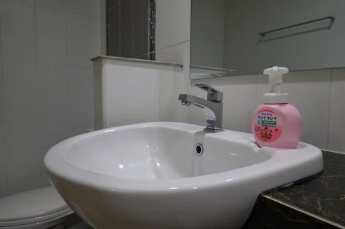 a bathroom with a sink with a soap bottle on it at Cozy house in Chiang Mai