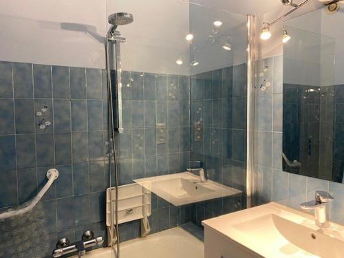 La salle de bains est pourvue d'une douche, de 2 lavabos et d'un miroir. dans l'établissement F2 4 Pers, Clim, WiFi, Terrasse, Garage - Amélie-les-Bains - FR-1-703-46, à Amélie-les-Bains-Palalda