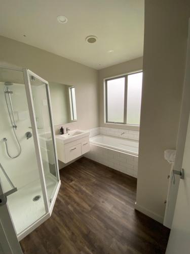 Un baño con ducha, bañera y lavabo. en Wanaka Holiday, en Wanaka