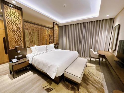 a bedroom with a bed and a desk and a television at Phoenix Pool & Golf View Villa Cam Ranh in Cam Ranh