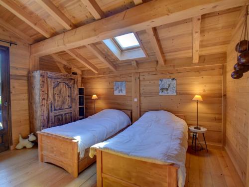une chambre avec deux lits dans une cabane en rondins dans l'établissement Superbe Chalet Neuf à Morzine - Cheminée, Terrasse et WiFi - FR-1-524-130, à Morzine