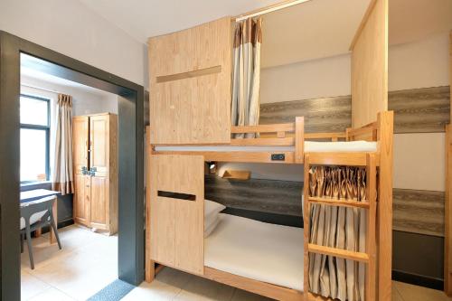 a bunk bed in a room with wooden walls at Kunming Upland International Youth Hostel ,near the city center ,2 mins walk to the subway, 2 mins walk to the Green Lake, Close to Yuan tong Temple, Old street, Yunnan University, convenient payment and visa cards are accepted in Kunming