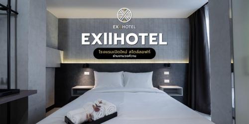 a bedroom with a bed with a sign on the wall at EX2 Hotel in Ban Bang Khen (1)