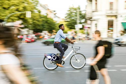a man riding a bike down a city street at Leipzig Marriott Hotel in Leipzig