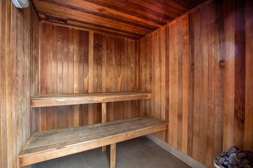 a sauna with wooden walls and wooden shelves at Rolling Surf Resort in Caloundra